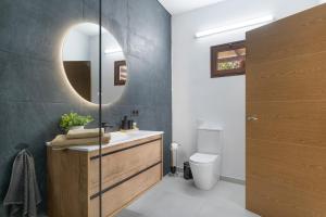 a bathroom with a sink and a mirror and a toilet at Casita Lanzarote in Teguise +14 photos