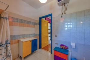 a bathroom with a yellow door and blue tiles at Sprocketlandia in Frigole