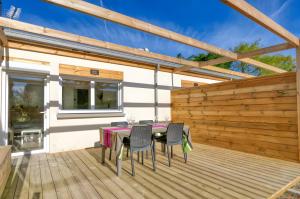 a wooden deck with a table and chairs on it at La Dune de Sable - Cavaro in Pornichet