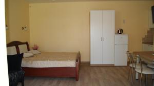 a bedroom with a bed and a white cabinet at VilaFėja Private courtyard house in Palanga