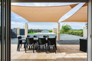 a patio with a table and chairs under awning at Gîte Koala in Marans