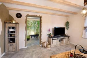 a living room with a tv and a large window at kernsaniertes Ferienhaus Anna in Durlangen
