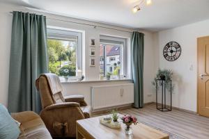 a living room with a chair and a window at Mentel´s Ferienwohnung in Knüllwald