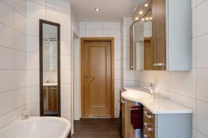 a bathroom with two sinks and a tub and a toilet at Mentel´s Ferienwohnung in Knüllwald +19 photos