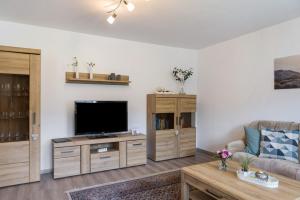 a living room with a tv and a couch at Mentel´s Ferienwohnung in Knüllwald