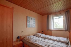 a bed in a room with a window and a bed sidx sidx sidx at Vogelhus Yvonne Vogel in Pellworm