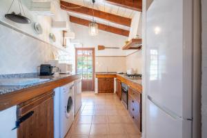 a large kitchen with a washer and dryer at Can Negri - Almadraba in El Port