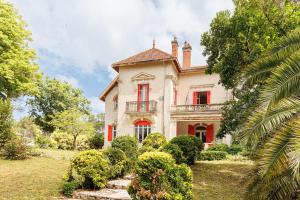 an oldstyle house with red windows and a balcony at Etage maison bourgeoise dans Parc in Soorts-Hossegor
