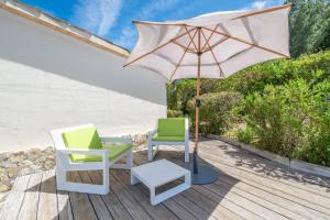 a patio with two chairs and an umbrella at Can Negri - Almadraba in El Port