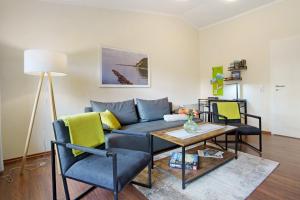 a living room with a couch and a table and chairs at Ferienwohnung To Hus in Putbus