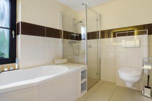 a white bathroom with a tub and a toilet at Ferienwohnung To Hus in Putbus +29 photos