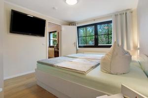 a bedroom with a bed with a television on the wall at Ferienwohnung To Hus in Putbus