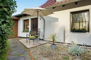 a patio with a table and an umbrella at Ferienwohnung To Hus in Putbus