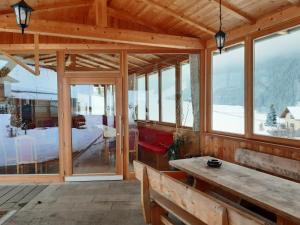 a wooden cabin with windows and a wooden table at Apartment Bärental - Gruberhof in San Giacomo