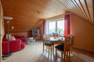 a living room with a table and a red couch at Vogelhus Yvonne Vogel in Pellworm