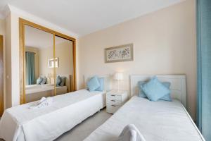 a bedroom with two beds and a mirror at Palmeiras Reais 110 in Portimão +20 photos