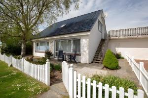a white house with a white picket fence at Vogelhus Yvonne Vogel in Pellworm