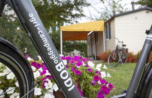a bike parked in a yard with flowers at Agricamping Ca' Bodi Veneto in Cavallino-Treporti