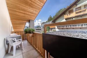 a balcony with a table and chairs on a building at Sonnleiten Sterngucker 10 in Collepietra