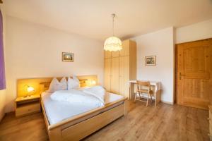 a bedroom with a bed and a table with a chair at Sonnenparadies Apartement 1 in Saltusio