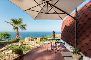 a patio with a table and an umbrella at Terre di Tusa in Tusa