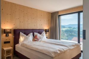 a bedroom with a large bed with a large window at Aumia Apartment Turmalin in Völs am Schlern