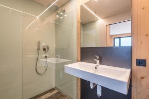 a bathroom with a sink and a shower at Aumia Apartment Turmalin in Völs am Schlern