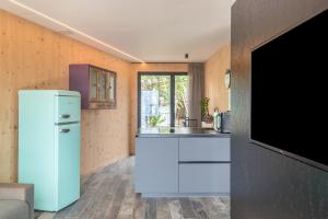 a kitchen with a white refrigerator and a tv at Aumia Apartment Turmalin in Völs am Schlern +20 photos