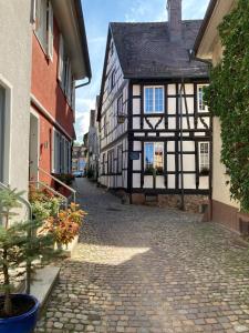 a cobblestone street in an old black and white building at Ferienwohnung Scheffelhaus in Gengenbach