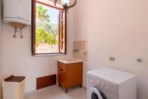 a bathroom with a washing machine and a window at Casa Viola 1 piano 100 mt dal mare in Trappeto