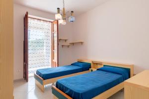 two beds in a room with a window at Casa Viola 1 piano 100 mt dal mare in Trappeto