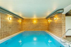 a swimming pool in a room with a tiled wall at Komfortwohnung mit Pool und Sauna in Hauzenberg