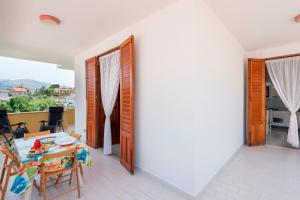 a room with a table and chairs and a balcony at Casa Viola 1 piano 100 mt dal mare in Trappeto