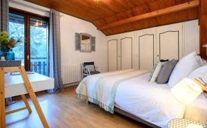 a bedroom with a bed and a desk and a window at Chalet du cret in Lathuile