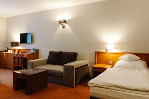 a hotel room with a bed and a chair at Hotel Santin in Bełchatów