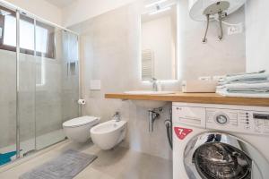 a bathroom with a washing machine and a shower at Comfort Appartamento Le Cementine in Tremosine Sul Garda +22 photos