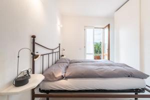 a bedroom with a bed and a lamp on a table at Comfort Appartamento Le Cementine in Tremosine Sul Garda