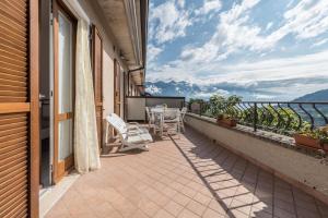 a balcony with chairs and tables on a building at Comfort Appartamento Le Cementine in Tremosine Sul Garda