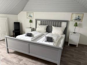 a bedroom with a large bed with white sheets and pillows at Ferienhaus Stemmert in Gelting