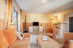 a living room with a couch and a tv at Schwalbennest in Buschvitz