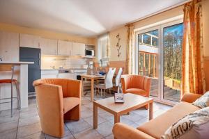 a kitchen and a living room with a table and chairs at Schwalbennest in Buschvitz