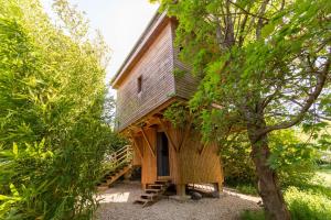 a tree house with a staircase leading up to it at La Cabane Perchée in Vert