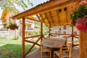 a wooden pergola with a wooden table and chairs on a deck at Chalet Belamy Studio 1 in Courchevel