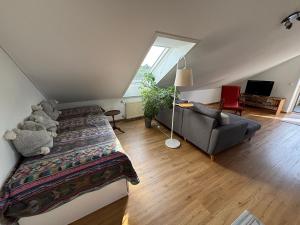 a bedroom with a bed and a couch and a window at Casa Lenny and Friends in Anzing