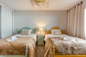 a bedroom with two beds and a lamp and a window at Referta Apartamento T2 in Prazeres