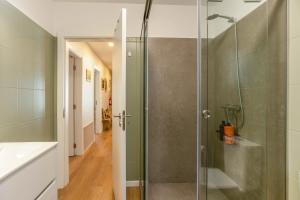 a bathroom with a shower with a glass door at Referta Apartamento T2 in Prazeres +18 photos