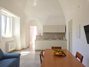 a kitchen with a table with a bowl of fruit on it at Syrenia Home in Vico Equense
