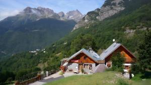 a house on a hill with mountains in the background at Chambre d'hôte Gite Passoud in Oz