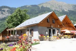 a building with tables and chairs and mountains in the background at Chambre d'hôte Gite Passoud in Oz