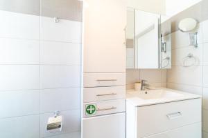 a white bathroom with a sink and a mirror at Contessa di Corfu i in Corfu +15 photos